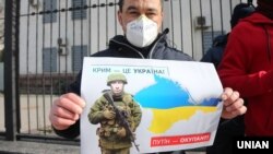 Плакат із зображенням президента Росії Володимира Путіна під час акції «Крим – це Україна» біля російського посольства в Києві, 16 березня 2020 року