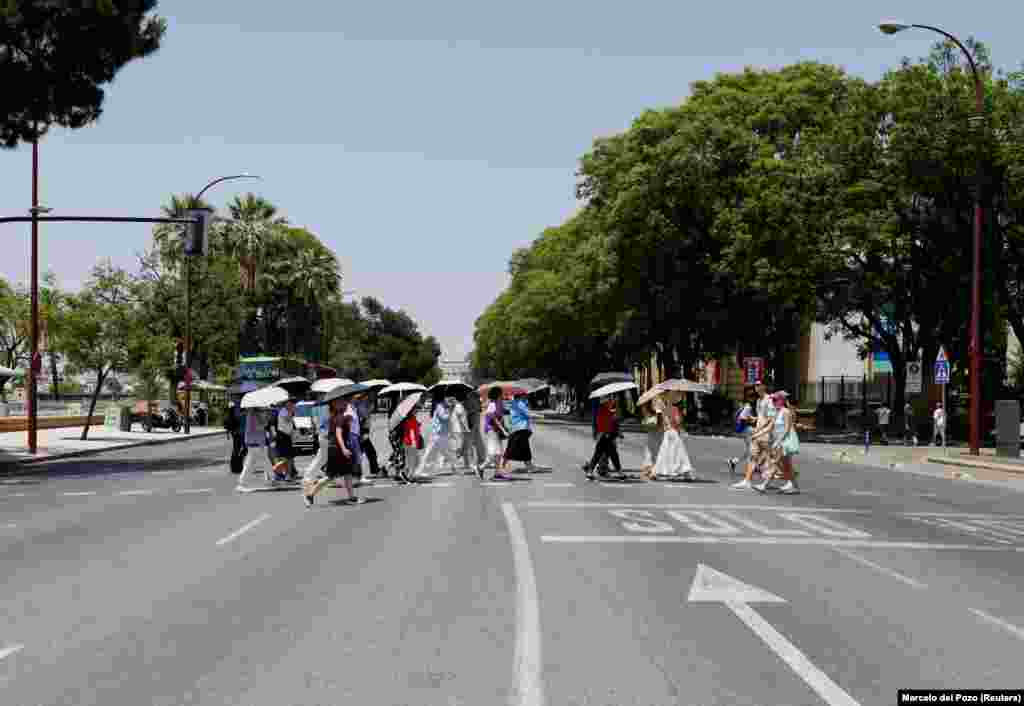 Turistë duke u mbrojtur me ombrella dielli në Sevillë, më 29 qershor.