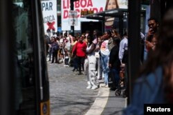 Жители Лиссабона ждут автобуса на остановке – из-за остановки электротранспорта в столице Португалии 28 апреля