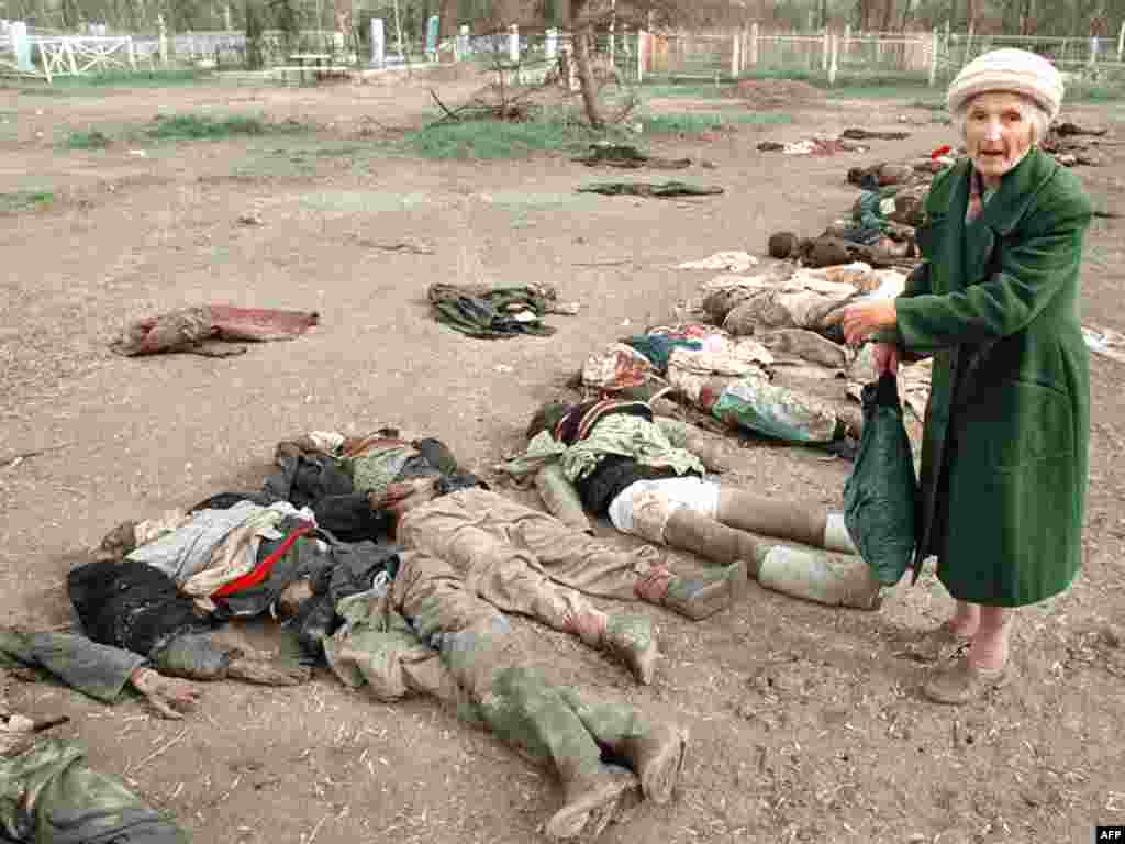 Русская женщина показывает на тело своего сына, который исчез во время налета авиации на Грозный. Он вышел из убежища за водой, 31 марта 1995