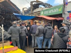 დაზარალებული მოვაჭრეები შეკრებილები არიან ბაზრობის ერთ-ერთ შესასვლელთან და ელოდებიან, როდის მისცემენ თავისი მაღაზიების ნახვის შესაძლებლობას