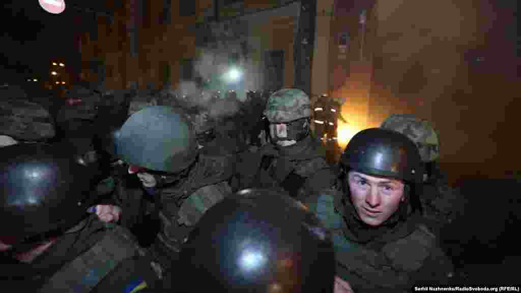 Протестующие бросают камни и пиротехнические средства через головы милиции 