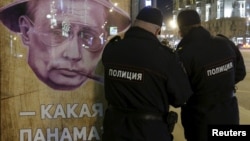 Полиция у постера с Владимиром Путиным "Какая Панама?" на остановке в Москве