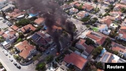 Pogled iz vazduha prikazuje vozila u plamenu dok se rakete lansiraju iz pojasa Gaze, u Aškelonu, južni Izrael, 7. oktobra 2023.