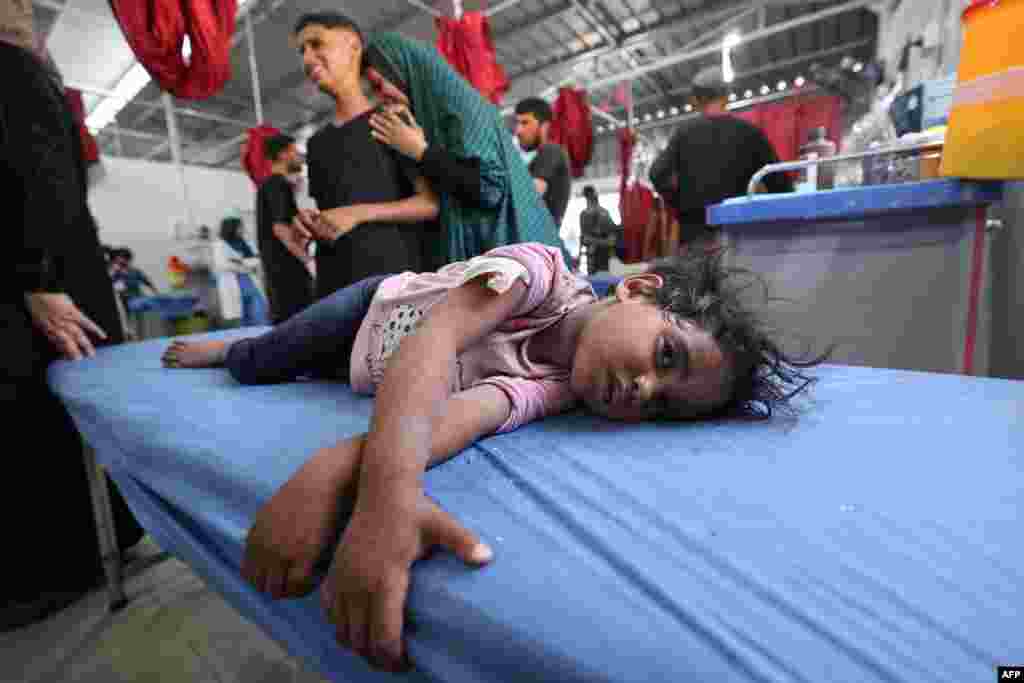 Žena i dijete plaču dok djevojčica leži na bolničkom krevetu čekajući prvu pomoć u bolnici Al-Awda u izbjegličkom kampu Nuseirat u centralnom Pojasu Gaze, 19. maja 2025.
