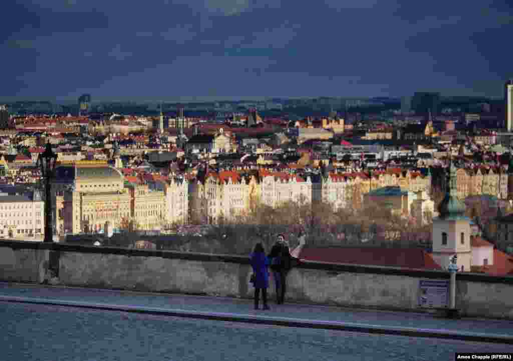 ორი ტურისტი ერთმანეთს უღებს ფოტოს „პრაჟსკი ჰრადის“ მახლობლად მდებარე გადასახედ მოედანზე, სადაც, ჩვეულებრივ, უამრავი ადამიანი ირევა.