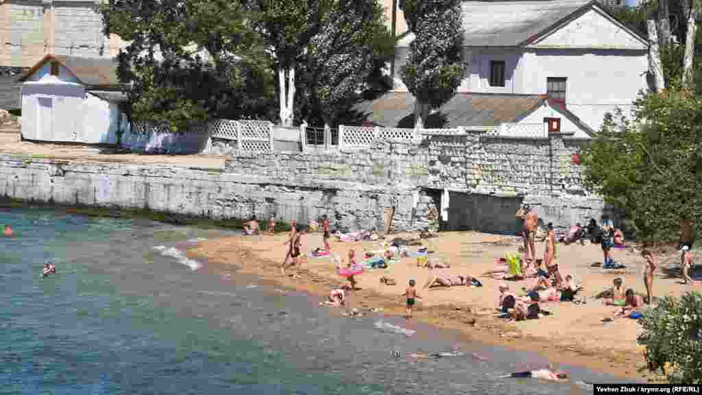 Небольшой песчаный пляж рядом с официальным бетонным пляжем «Ушакова балка» в Нахимовском районе Севастополя. Местные жители называют его пляжем «Угольная бухта»