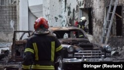 Firefighters work at the site of buildings damaged during Russian drone and missile strikes in Lviv, July 12, 2025.