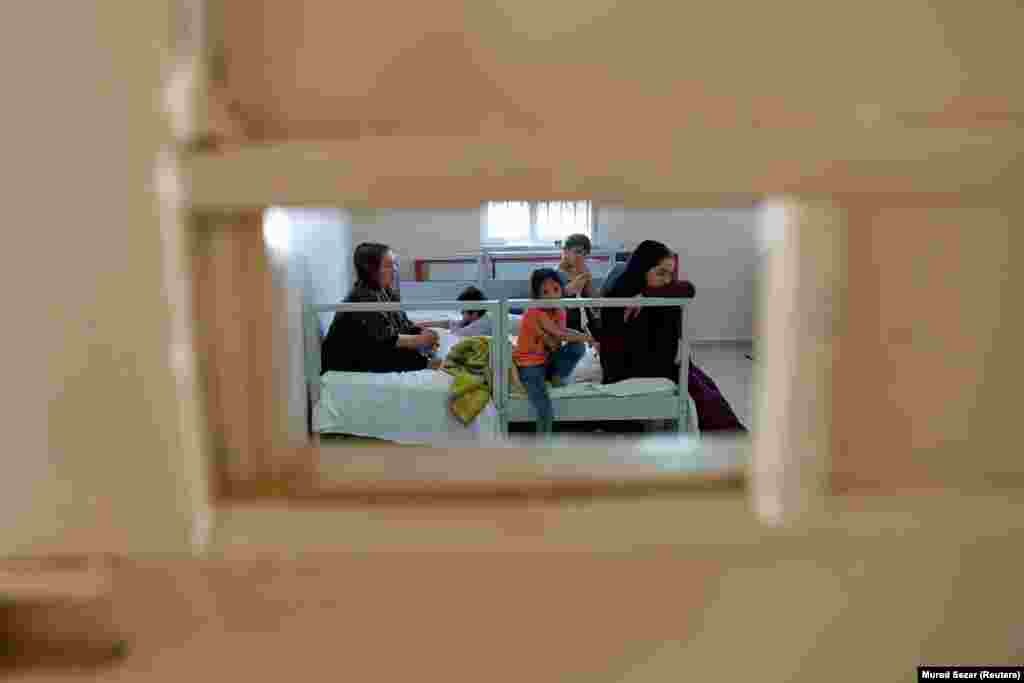 Porodica migranata iz Afganistana, koju su turske snage sigurnosti privele nakon ilegalnog ulaska u Tursku iz Irana, u sobi centra za rad sa migrantima u pograničnom gradu Van, Turska (22. avgust)