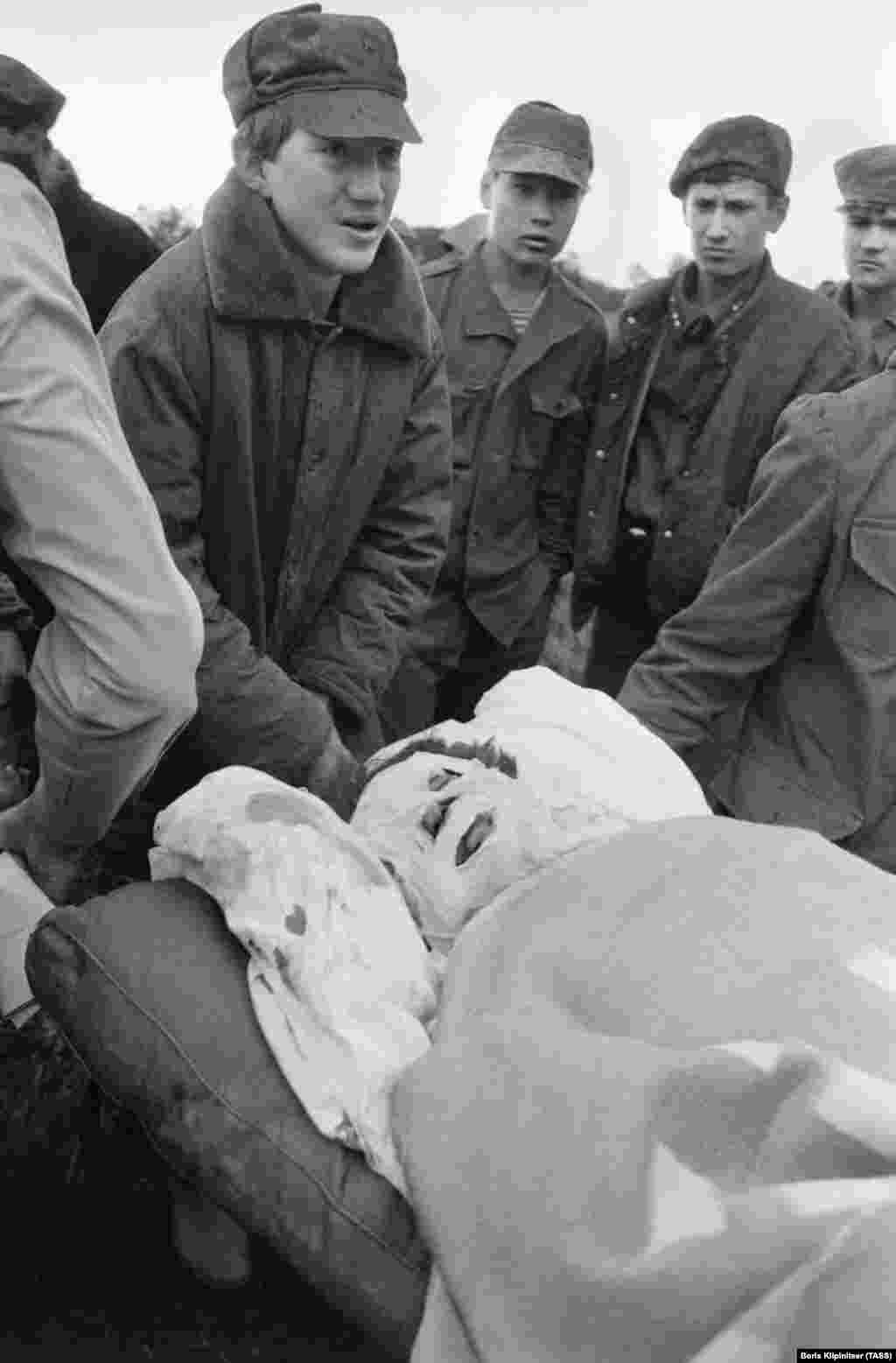 Человека с сильными ожогами эвакуируют с места трагедии.  