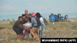 Місцеві мешканці несуть постраждалого від стихійного лиха на острові Сулавесі, 29 вересня 2018 року