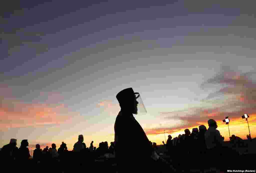 Мусульмане молятся в ожидании новолуния, знаменующего начало священного месяца, на набережной Си-Пойнт в Кейптауне. ЮАР, 12 апреля 2021 года.