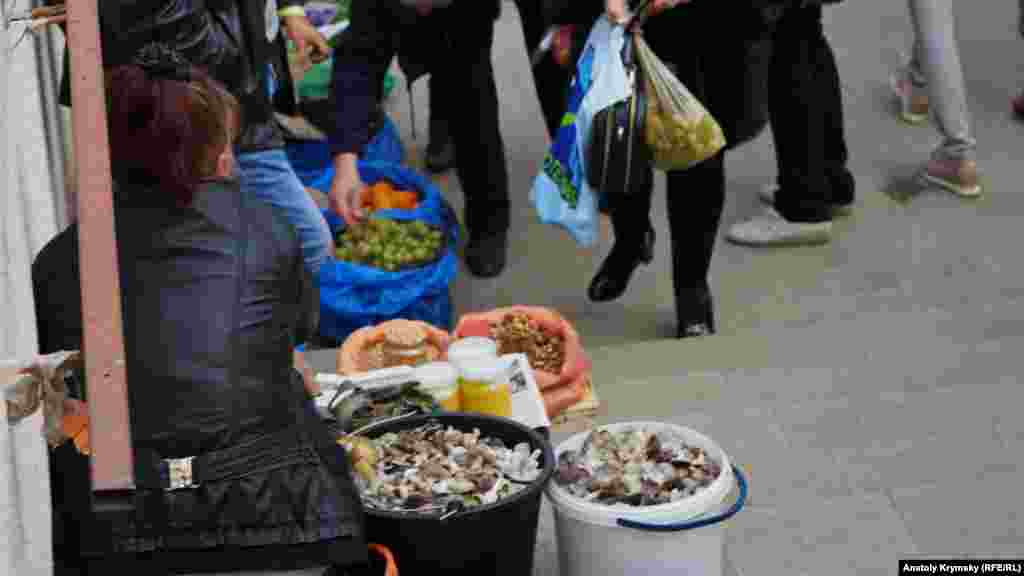 В подземном переходе на площади Куйбышева в Симферополе женщина продает два ведра «мышат», или серой рядовки