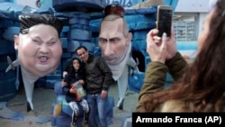 Фігури президентів Північної Кореї і Росії, Кім Чен Ина і Володимира Путіна, у вигляді акул на карнавалі в Португалії, 13 лютого 2018 року