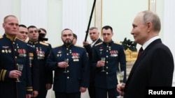 რუსეთის პრეზიდენტი ვლადიმირ პუტინი  უკრაინის წინააღმდეგ ომში მონაწილეობისთვის „ოქროს ვარსკვლავითა” და „რუსეთის გმირის” წოდებით დაჯილდოებულ სამხედრო მოსამსახურეებთან ერთად. მოსკოვი, 2025 წლის 23 თებერვალი