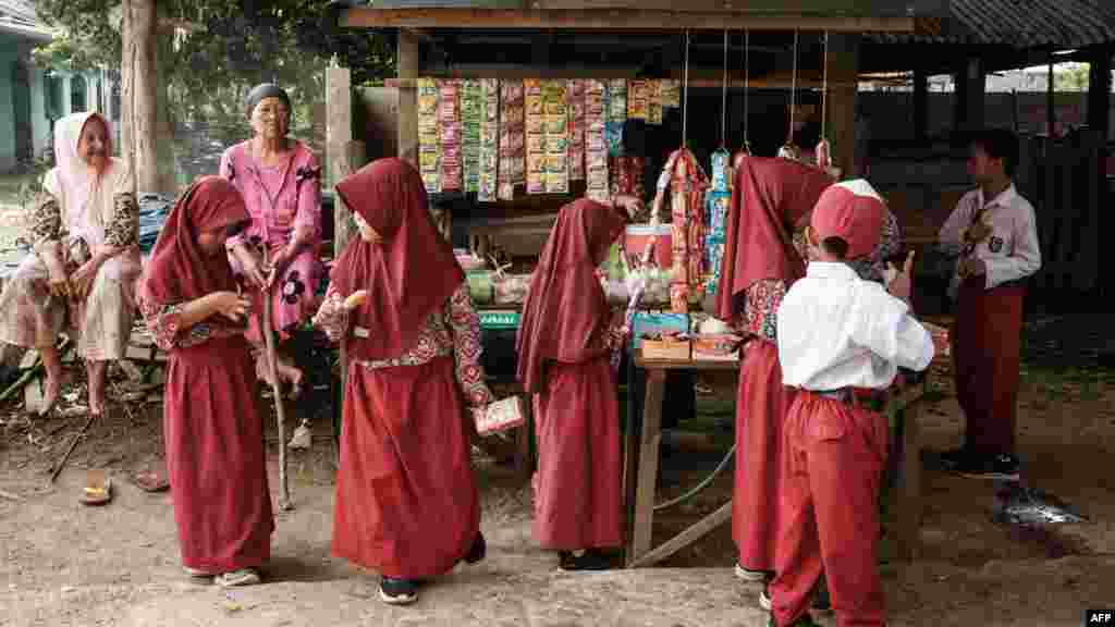 Na fotografiji: djeca kupuju sokove i grickalice prije nastave u Bangsalu."Zdravo tresetište je kao pluća Zemlje", rekao je za AFP Muhammad Husin, lokalni uzgajivač bivola. "Ako uspijemo zaštititi prirodu, priroda će zaštititi i nas."