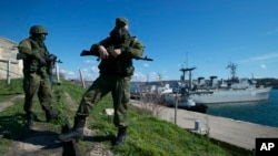 Ruski vojnici čuvaju pristanište na kome su usidrena dva ukrajinska vojna broda u Sevastopolju, na Krimskom poluostrvu, 5. mart 2014.
