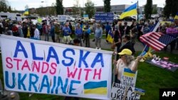 Demonstranti mašu zastavama i drže transparent dok se okupljaju u znak podrške Ukrajini pored autoputa u Ankoridžu, Aljaska, uoči sastanka 15. avgusta između predsjednika SAD-a i Rusije.