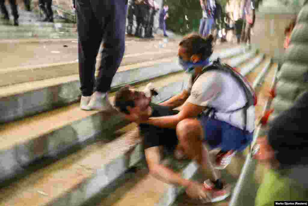 Поранений демонстрант отримує першу допомогу під час масових акцій протесту проти комендантської години у Белграді. Детальніше про перебіг подій у столиці Сербії дивіться у фоторепортажі Радіо Свобода