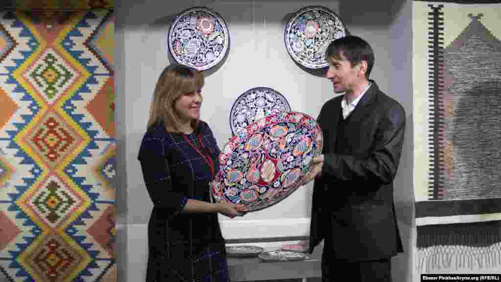 Мастер-гончар Эдем Ганиев, который создает керамику с традиционным крымскотатарским орнаментом, дарит свою работу библиотеке имени Ивана Франко в Крыму на выставке «Крымское соцветие». Февраль 2019 года