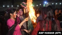 Pakistani Hindu women dance covered in colored powder as they celebrate the Holi festival in Karachi on March 20.