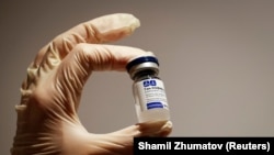 Medicinski radnik drži bočicu Sputnik V vakcine.